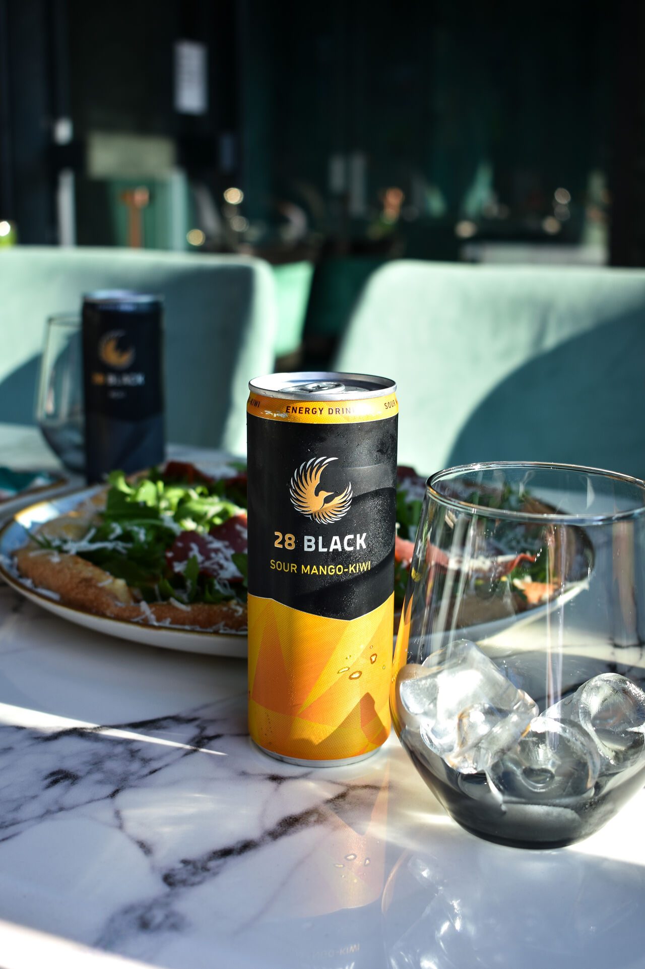 Salatteller und Energy-Drink auf einem Marmortisch in der Sonne